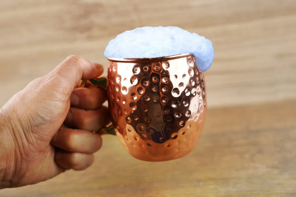 ayran in a copper mug being held, a popular istanbul drink