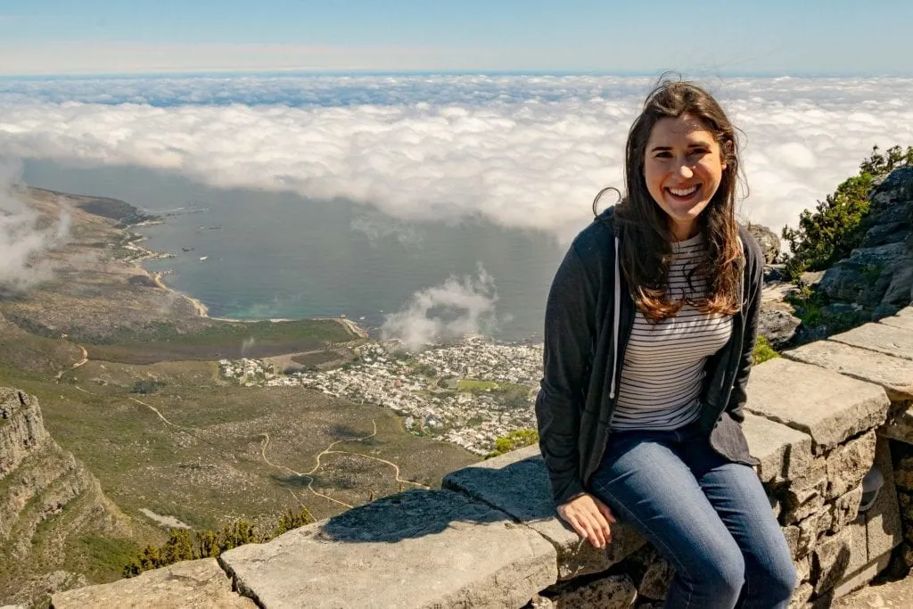 kate storm sitting over the clouds on table mountain cape town, one of the best stops itinerary south africa