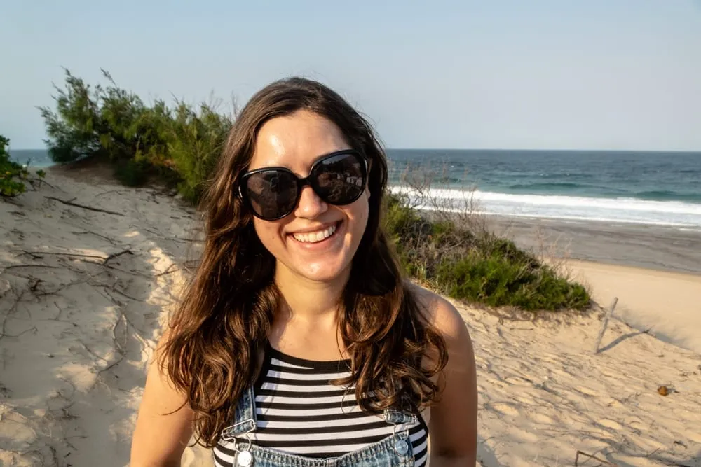 kate storm in tofo mozambique wearing sunglasses and a striped shirt