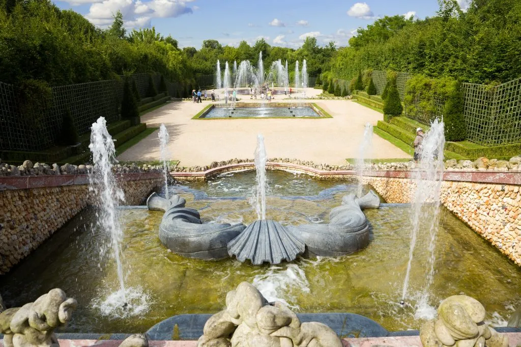 grove of 3 fountains spraying water on a day trip to versailles france