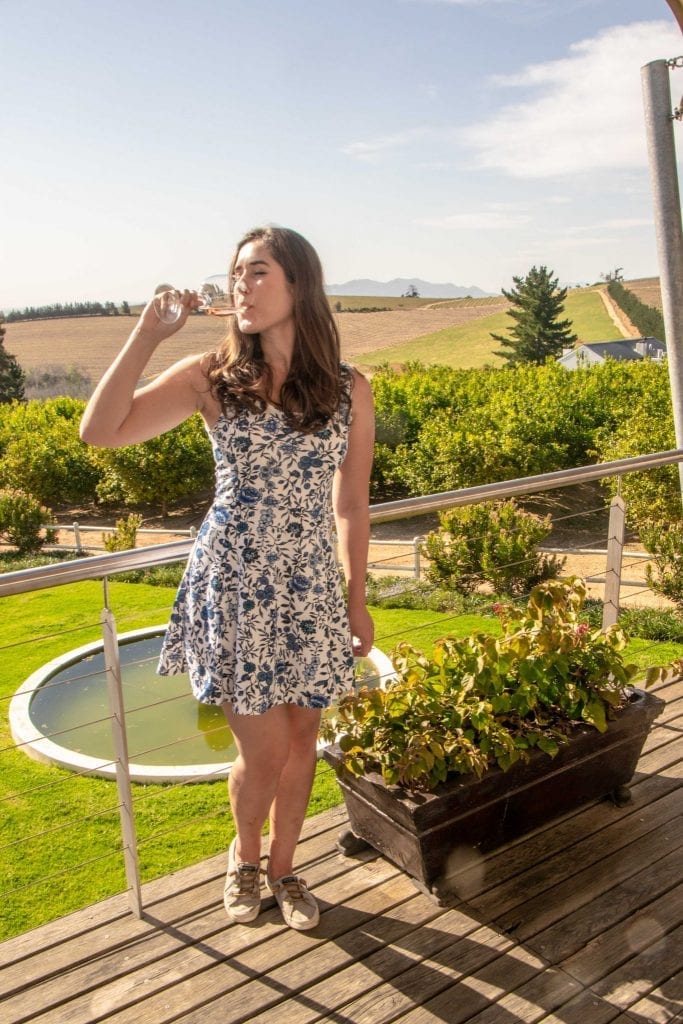 kate storm drinking a glass of wine at a vineyard in the cape winelands