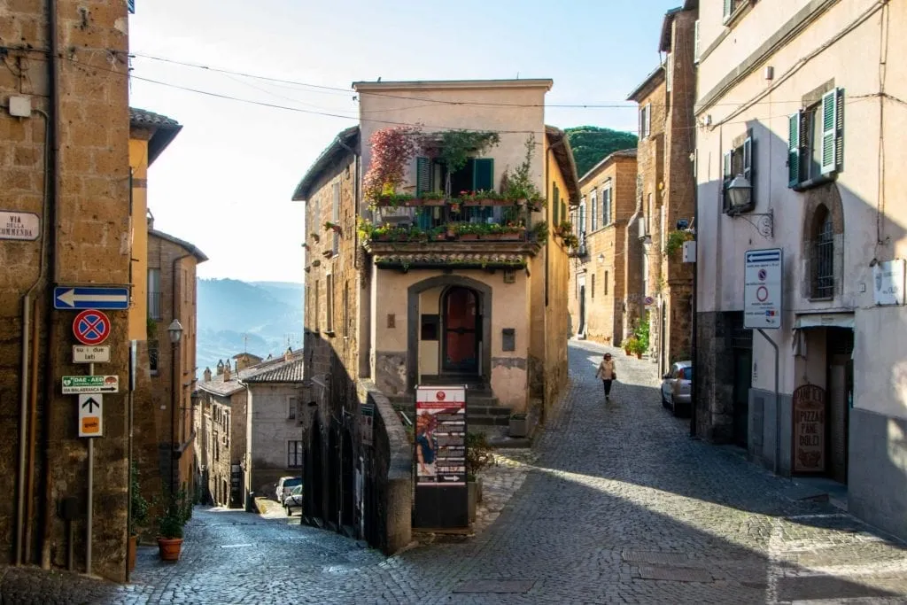 two cobblestone streets of orvieto italy with a narrow building between them