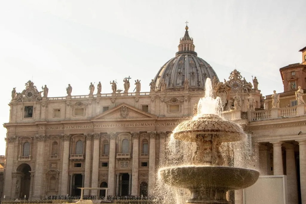 Close up of St. Peter's Basilica with fountain in the foreground as seen in St. Peter's Square--an essential stop when visiting the Vatican!