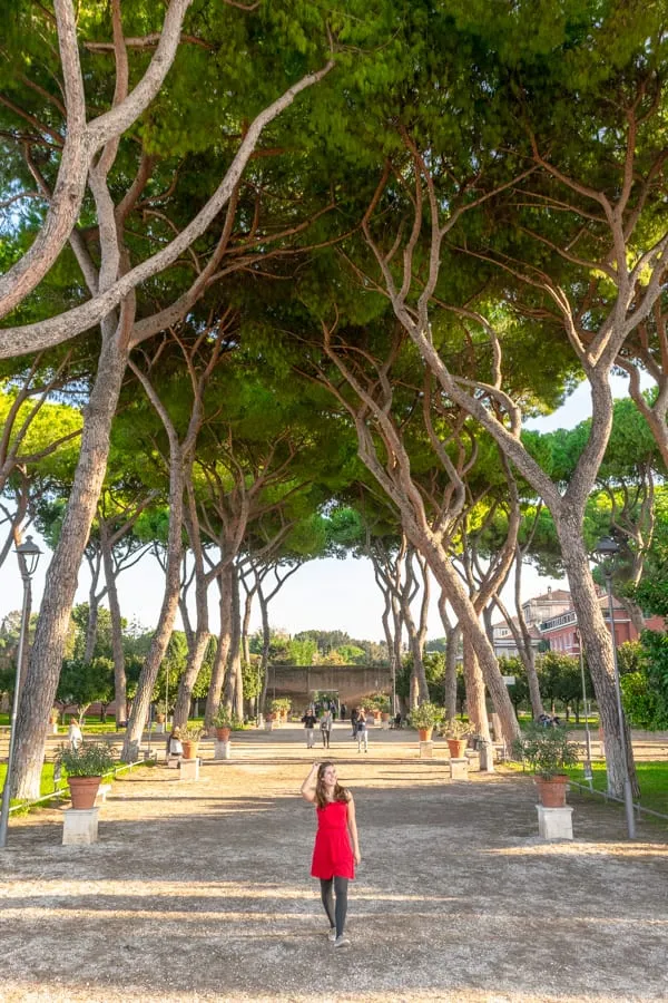 Kate Storm walking through Orange Garden in Rome Italy while wearing a red dress--a fun example of what to pack for Rome Italy