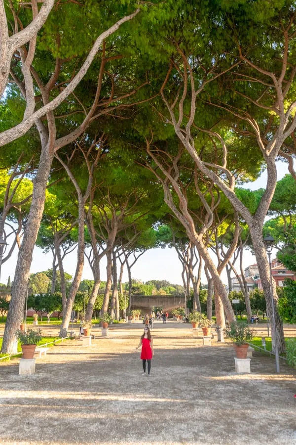 Kate Storm walking through Orange Garden in Rome Italy while wearing a red dress--a fun example of what to pack for Rome Italy