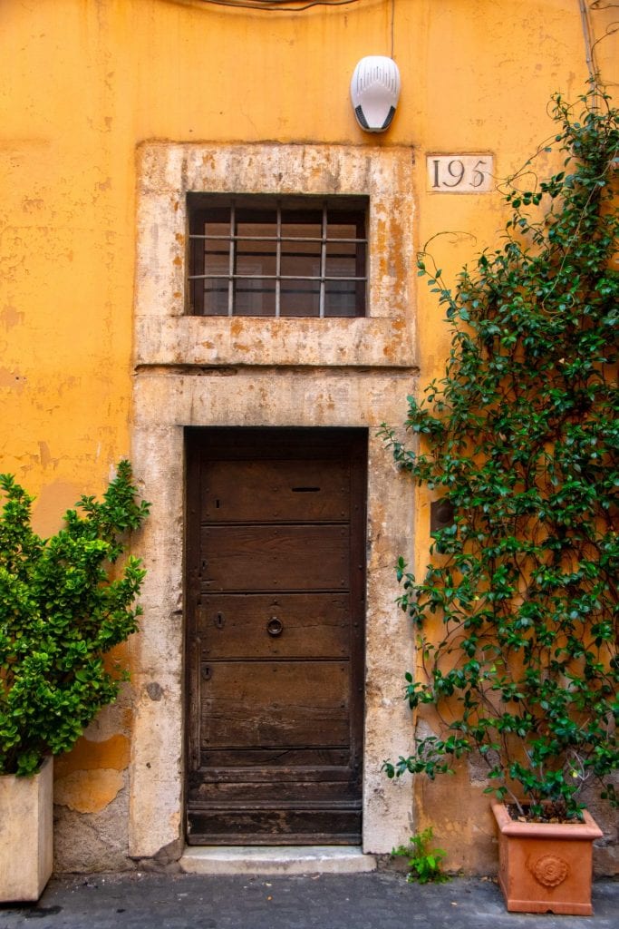 carved wooden door in a yellow building in rome italy