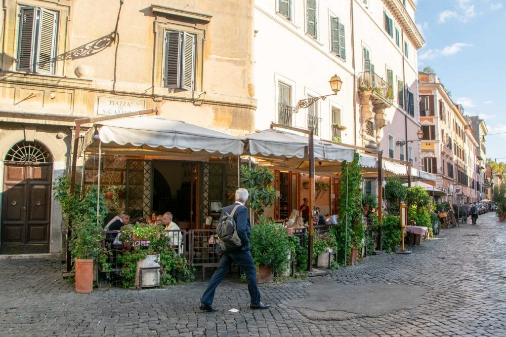 What to wear in Rome for men: man in Trastevere in front of restaurant