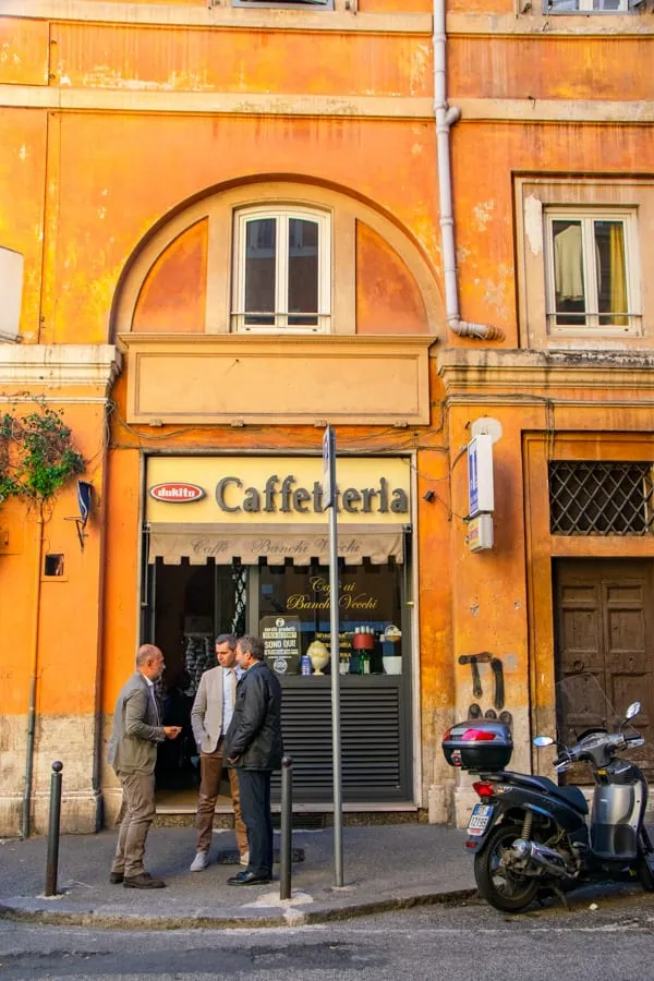 What to wear in Rome: three Roman men standing in front of a shop