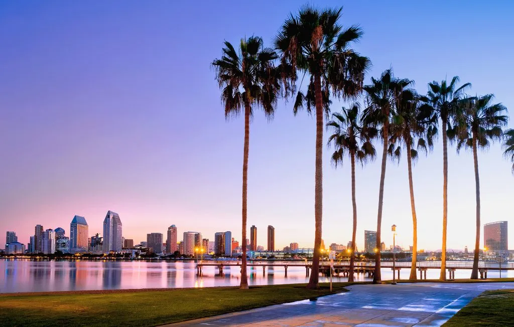 view of sunrise on coronado island california with palm trees in the foreground, one of the most romantic getaways in the us