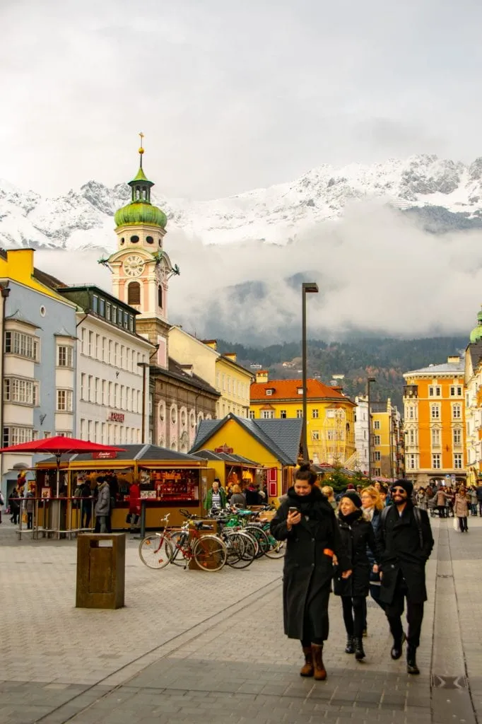 christmas market in innsbruck austria with mountain visible in the background, one of the best places for a christmas in europe itinerary