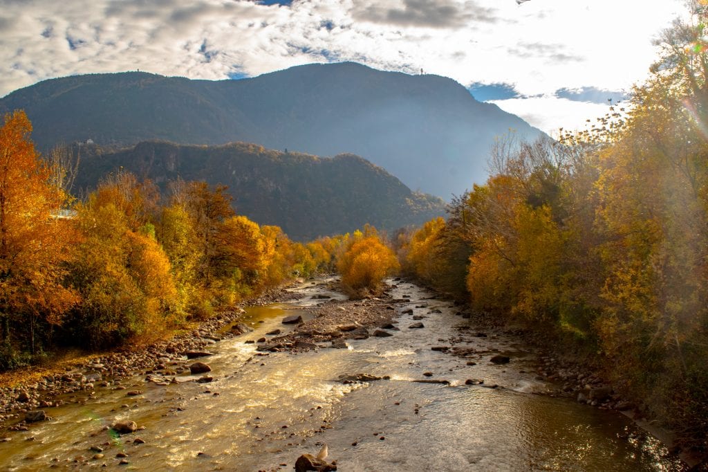 How to Use an Eurail Train Pass: photo of river surrounded by fall foliage in Bolzano.