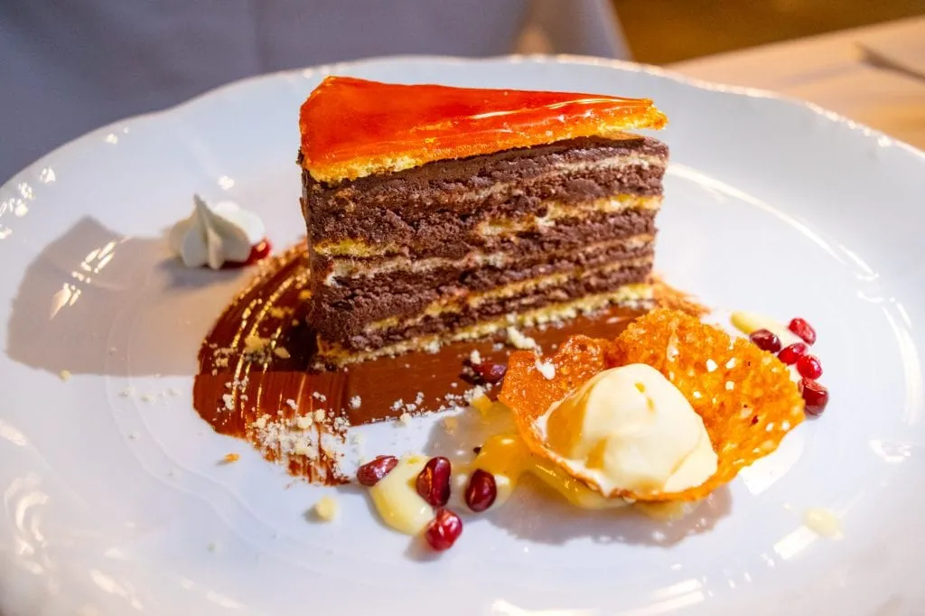 Slice of Dobas Torta on a white plate as served at Central Cafe in Budapest