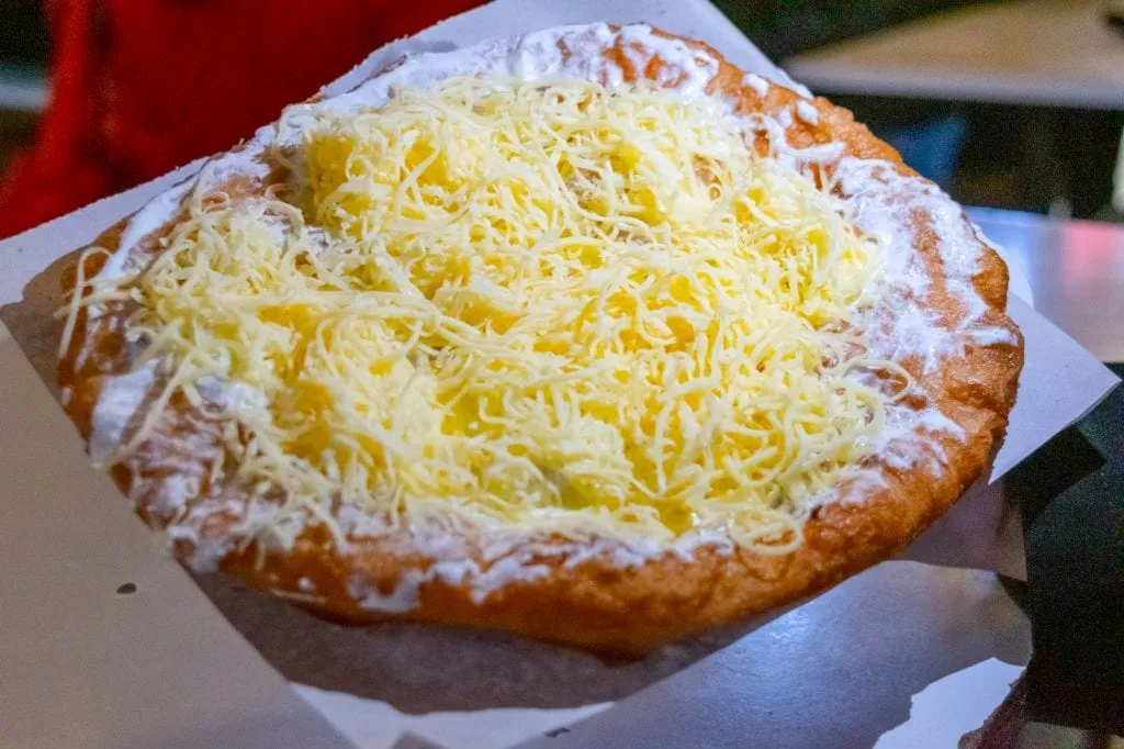 traditional hungarian langos with sour cream and shredded cheese, one of the best foods in budapest hungary