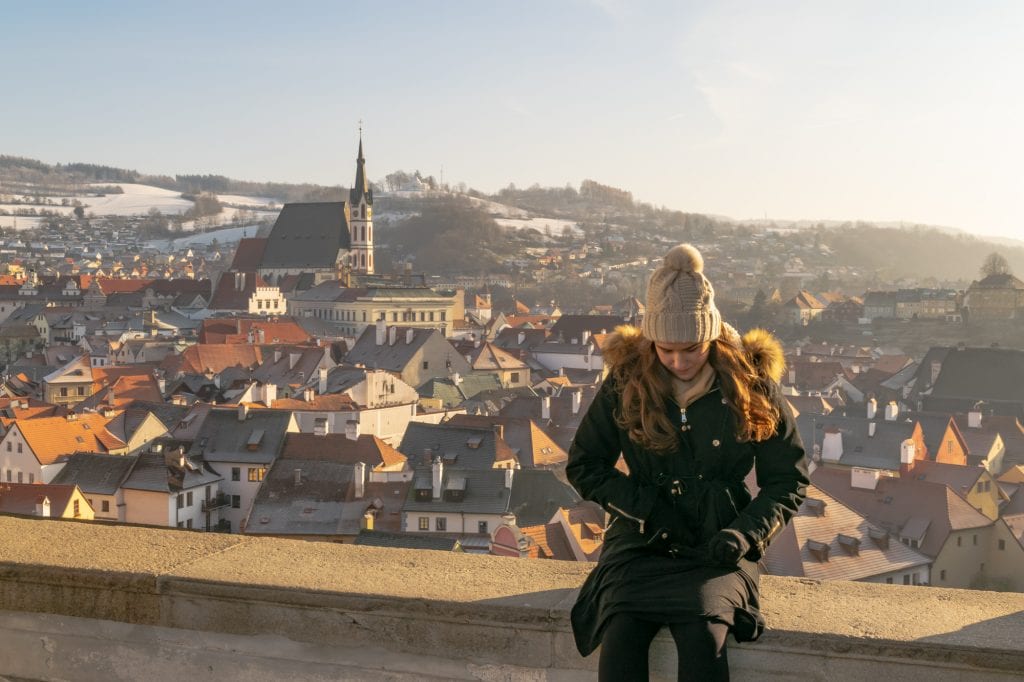 kate storm in a black coat overlooking cesky krumlov december