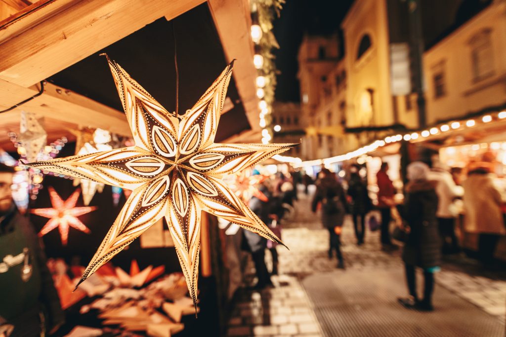people shopping in a market during christmas in austria with ornament in the foreground