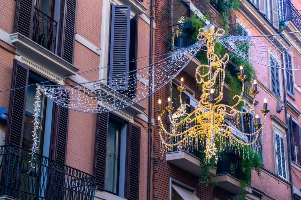 Christmas Lights Chandlier in front of pink Roman building: Rome in Winter