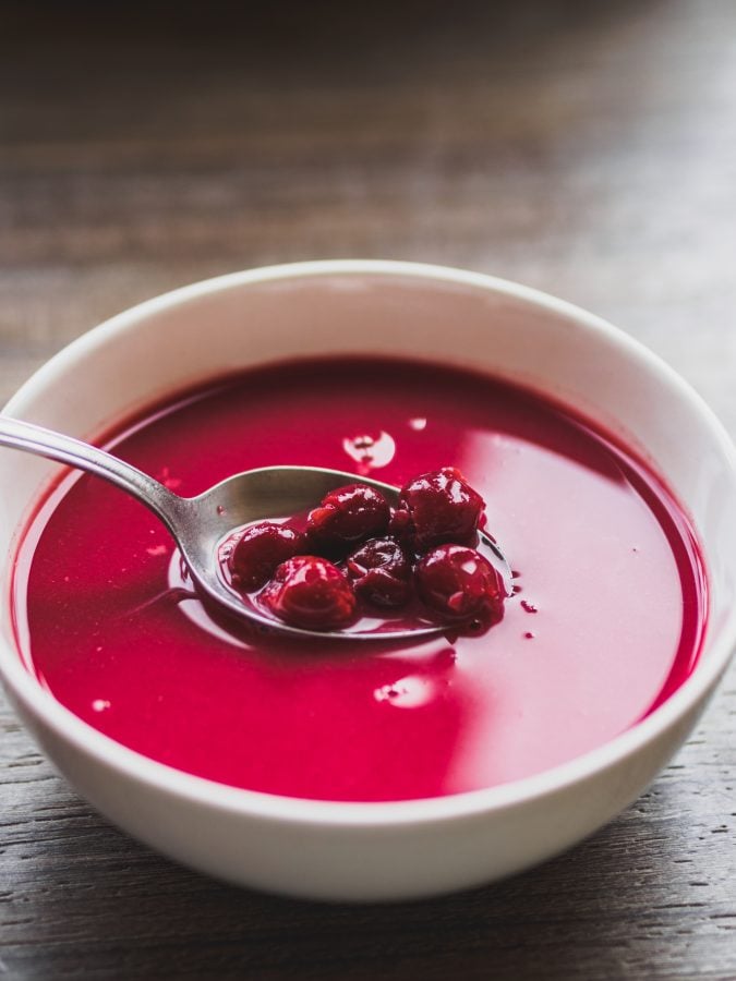 bowl of hungarian sour cherry soup with a spoon dipped in it