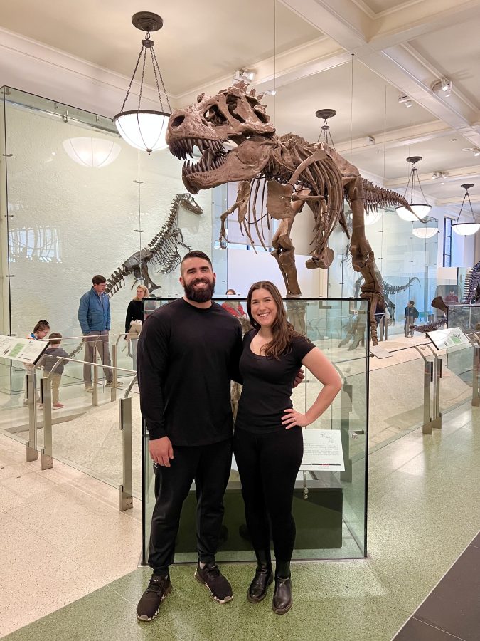kate storm and her brother in front of the t rex at the american museum of natural history, one of the best places to visit in nyc itineraries