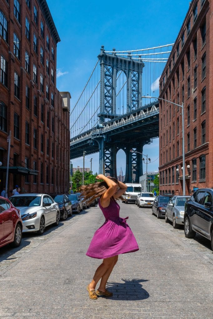 kate storm spinning in front of manhattan bridge in brooklyn, a must see duing 4 days in nyc