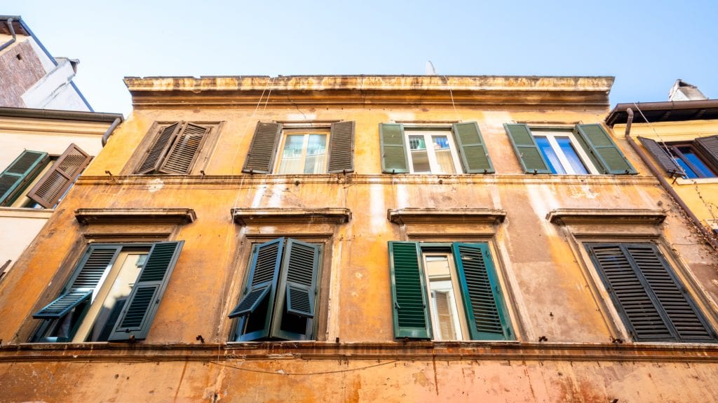 Yellow Building with Green Shutters as seen when looking up in trastevere rome
