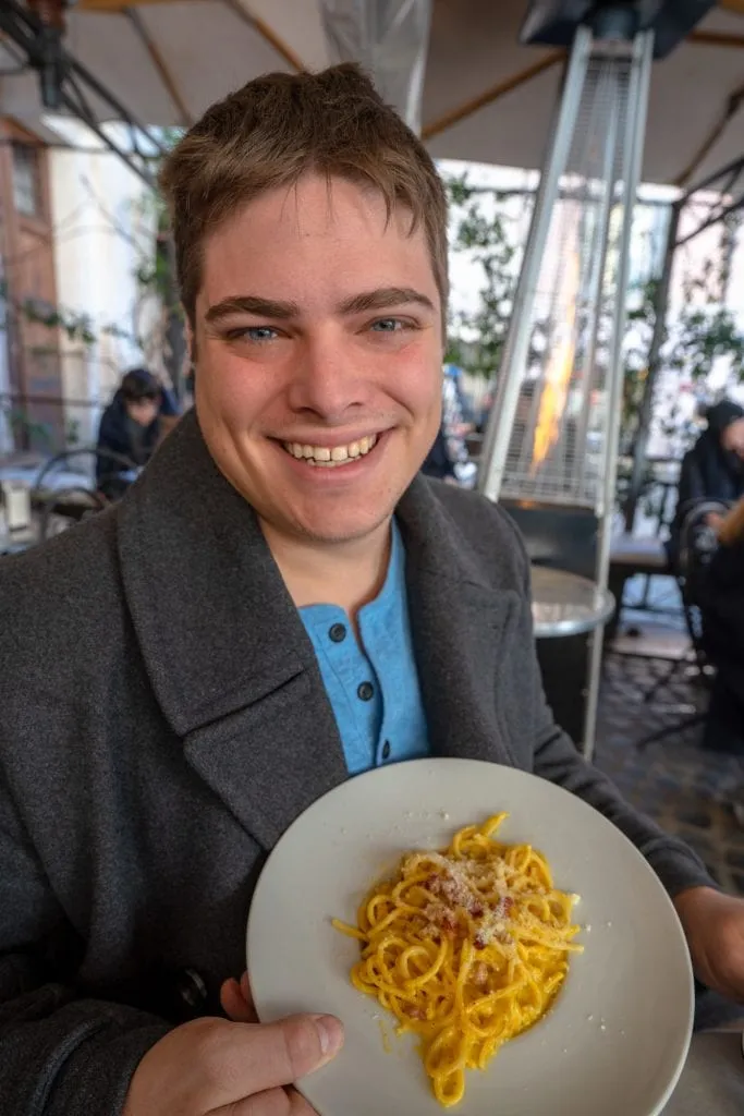 What to wear in Rome: man with a bowl of pasta