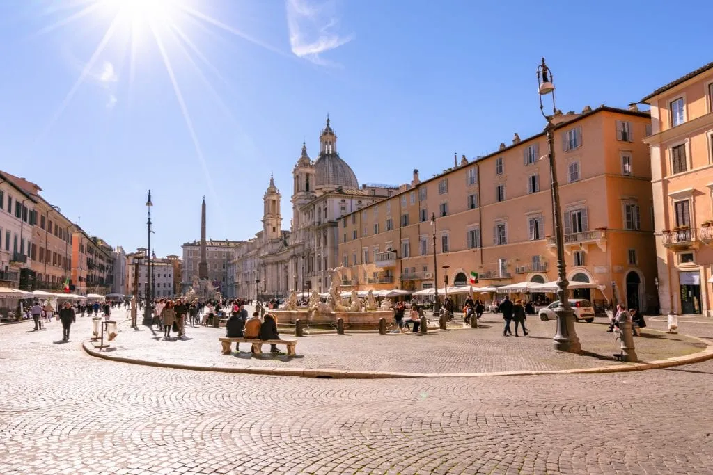 piazza navona in rome italy with a sun flare in the upper left