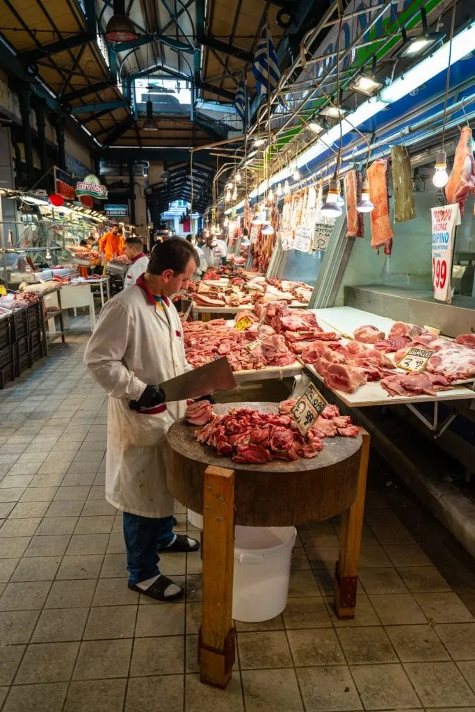Butcher chopping meat in Athens meat market, Athens food tour