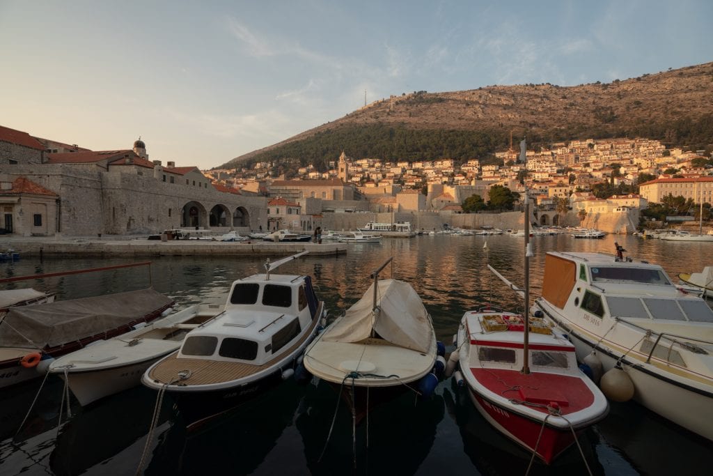 dubrovnik harbor with boats parked in it at sunset