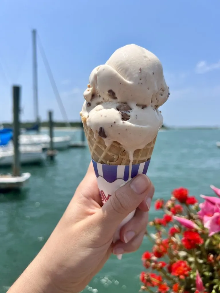 double scoop of ice cream from beaufort creamery being held out along marina, one of the best things to do in beaufort nc