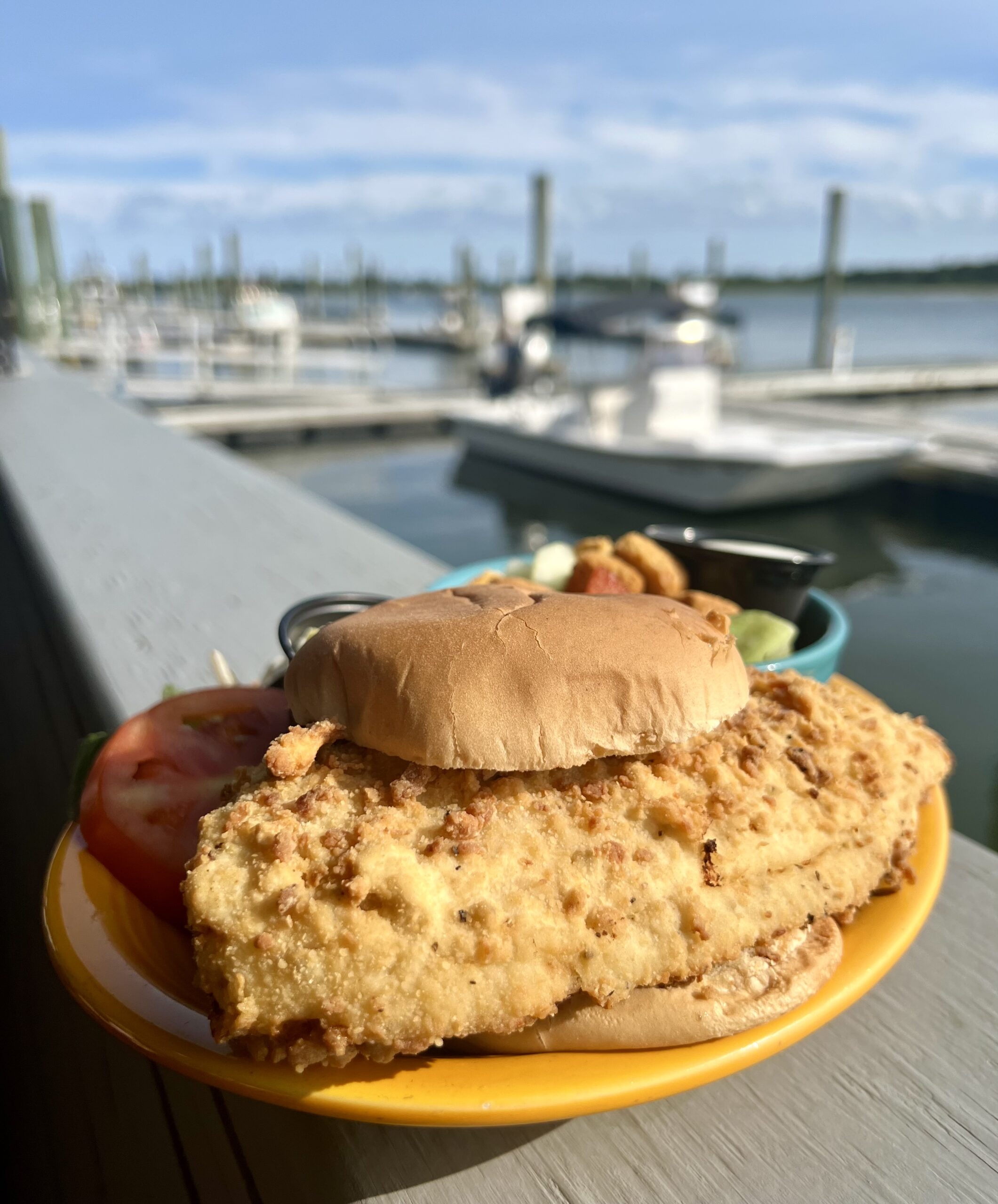 flounder sandwich at finz grill beaufort nc restaurant, sandwich on a plate set on the edge of a dock