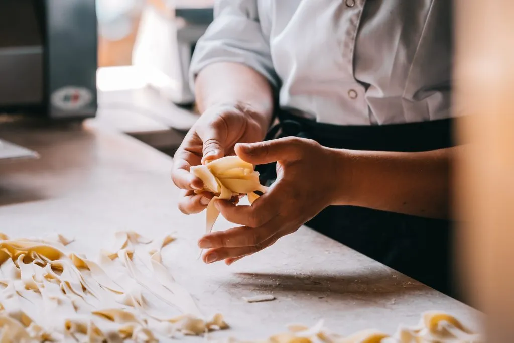 close up of people making pasta at a cooking class