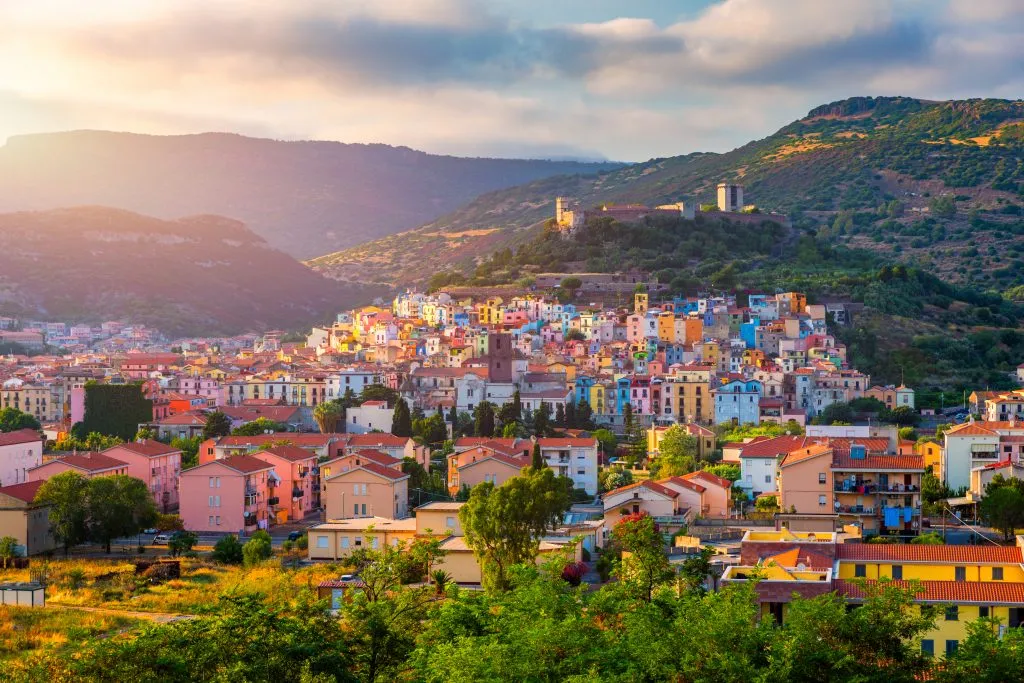 aerial view of the colorful buildings of bosa sardinia surrounded by mountains, one of the best seaside towns in italy