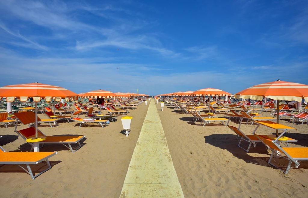 view of orange umbrellas set up in rimini, one of the best beaches in italy