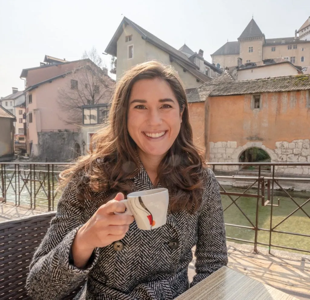 Woman drinking coffee by canal in Annecy, France--fun things to do in Annecy