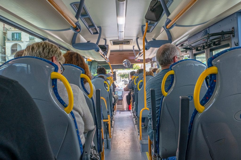 Photo of bus along the Amalfi Coast, with seats on each side and aisle in the middle. The bus is the cheapest, but not simplest, way of navigating your way through a 3 days on the Amalfi Coast.