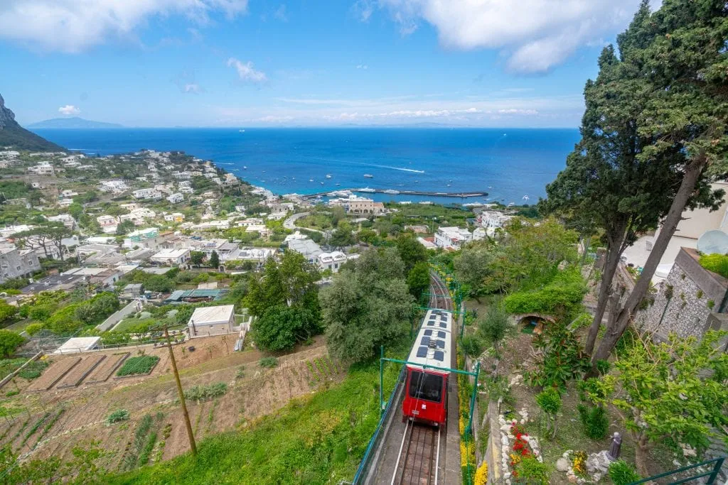 View of red funicular traveling up the hill to Capri Town