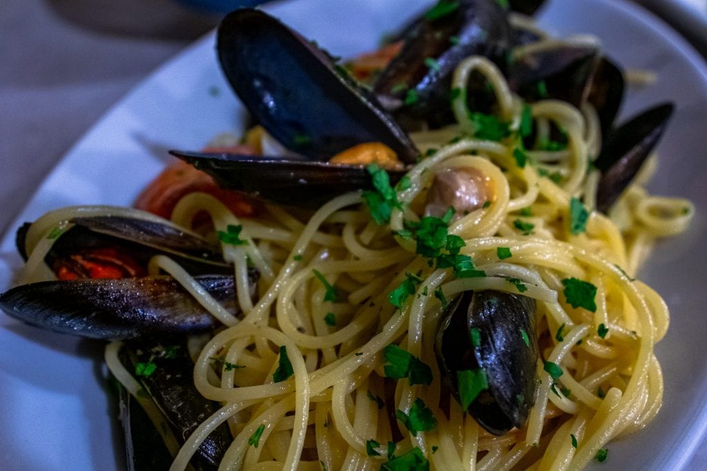 Plate of seafood pasta with mussels in it as served in Cinque Terre. Trying the seafood is among our many Cinque Terre tips!