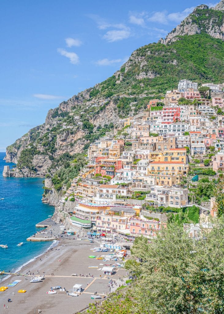 Photo of Positano from above on the Amalfi Coast, a classic Italy honeymoon destination. You can see Positano beach and the sea to the left.