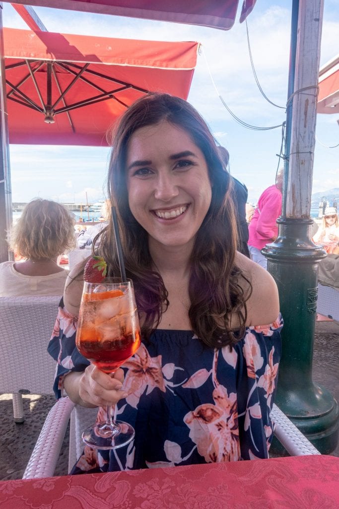 Woman with an orange cocktail underneath an umbrella on Capri.