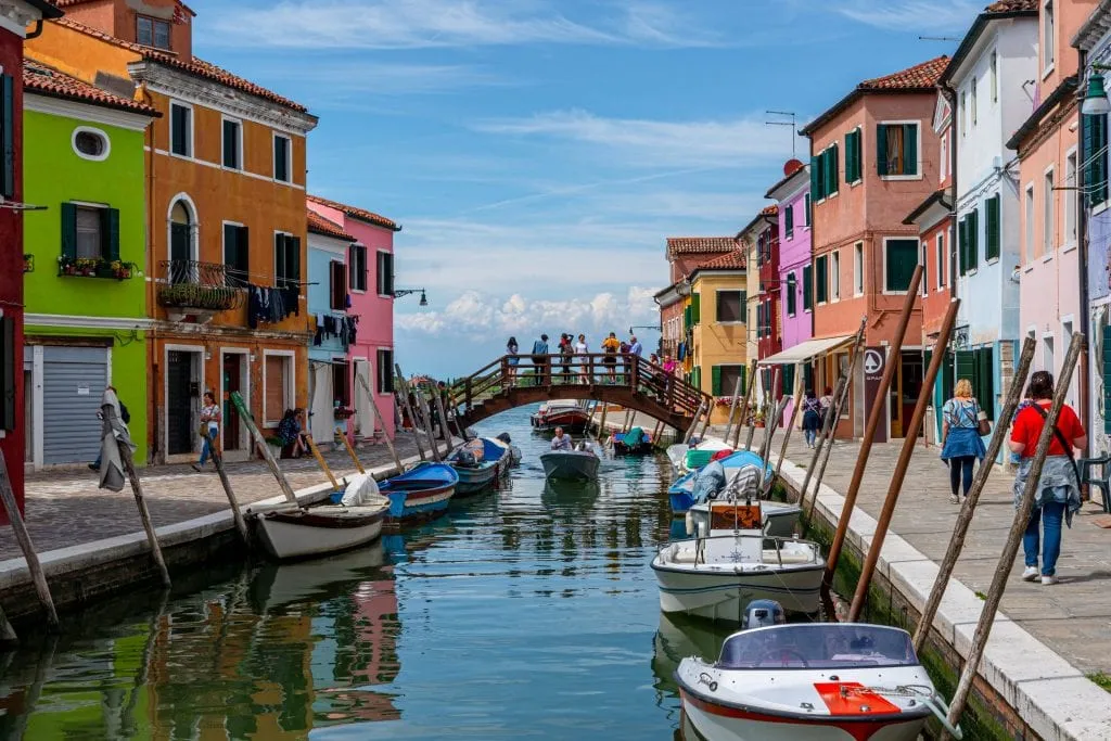 view of a canal in burano with colorful houses on either side, one of the best islands in venice to visit