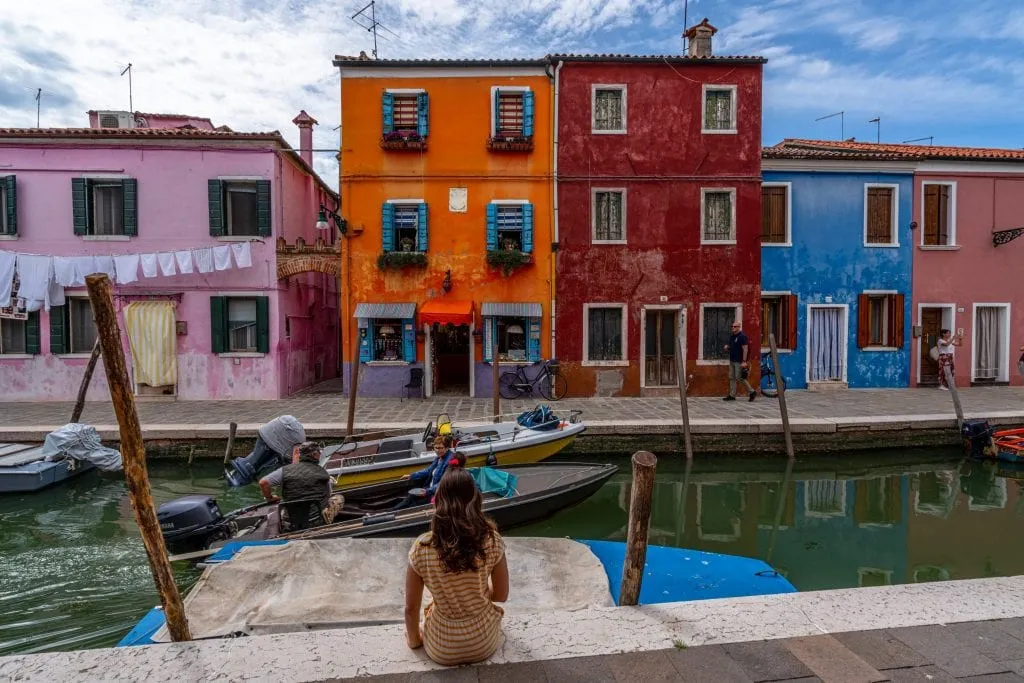 kate storm sitting on the edge of a canal in burano island venice italy