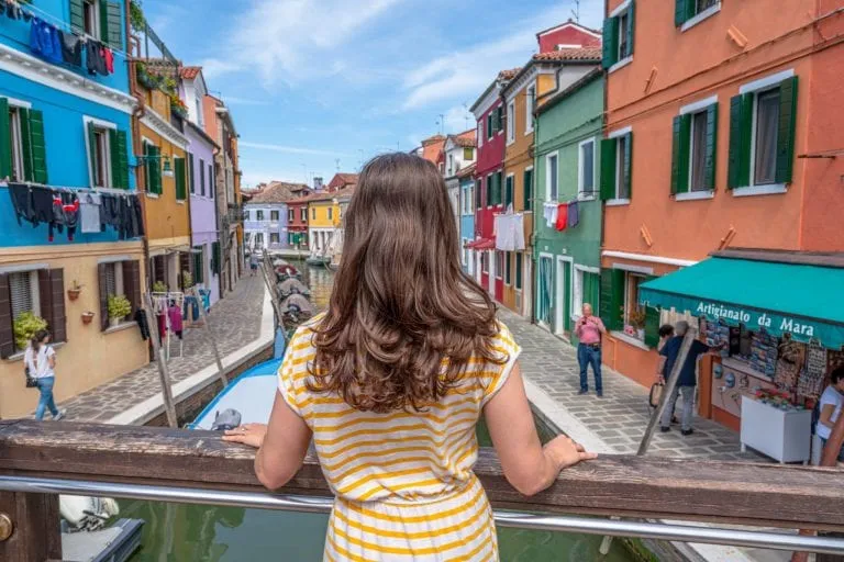 Photo of kate storm overlooking colorful houses of Burano from a bridge on a day trip from Venice to Burano.