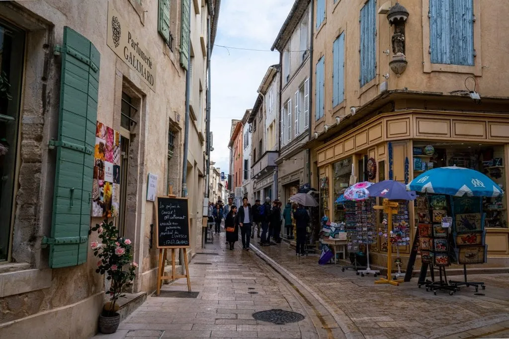 Pedestrian street in Saint-Remy-de-Provence France, framed by buildings with colorful shutters on either side.