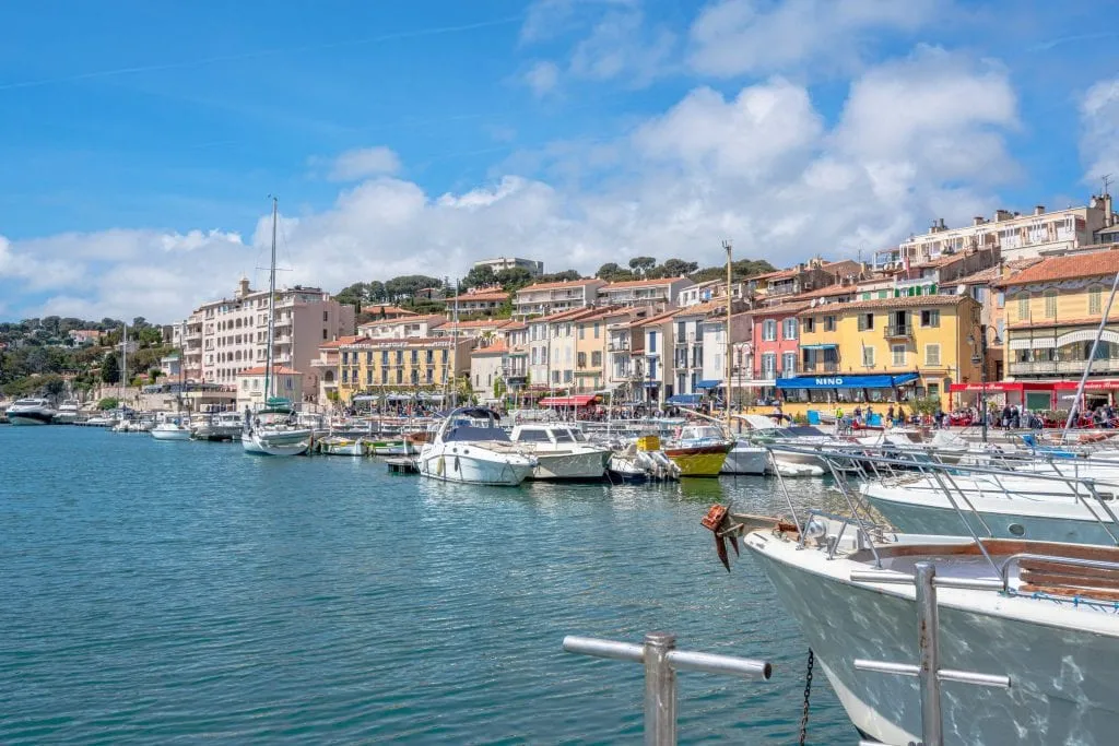 Port de Cassis shot from the side, with colorful buildings in the background behind the water