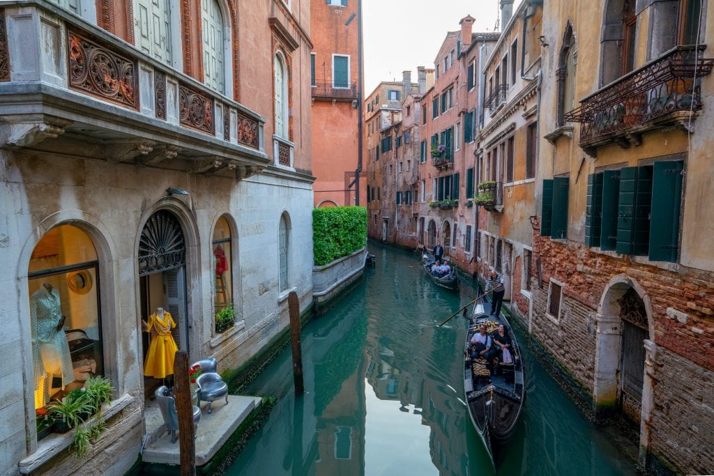 Photo of 2 gondolas in a small canal in Venice.