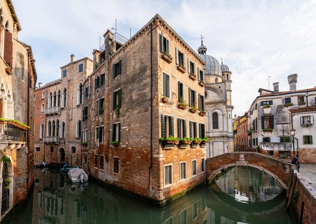 Canal in Venice, with a view of a bridge on the right.