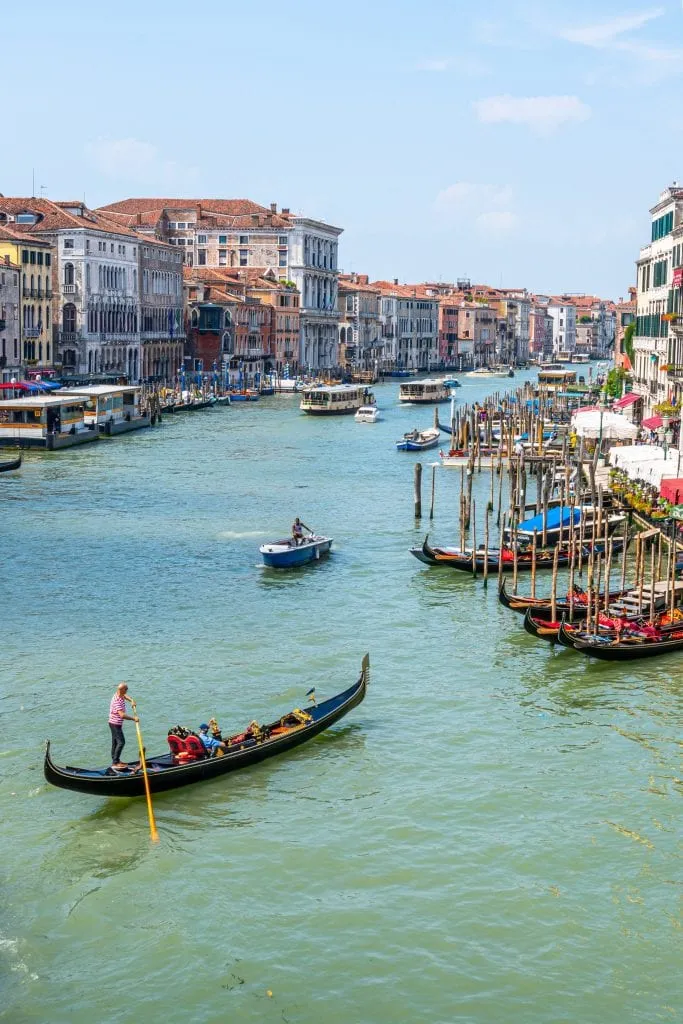 Venice Grand Canal with gondola paddling across it--a must-see item for your 2 week Italy itinerary!