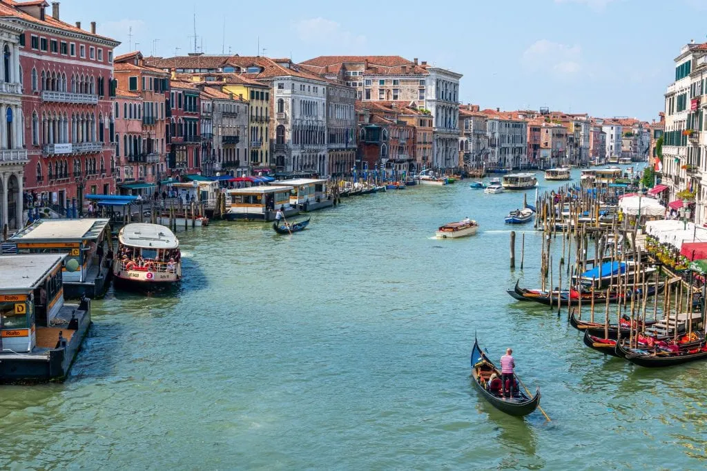 Photo of Grand Canal of Venice taken from Rialto Bridge, with a gondola in the bottom right corner--definitely find this view when spending one day in Venice!