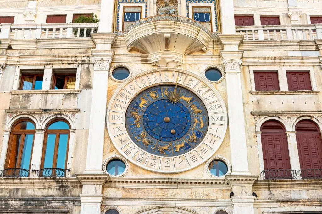 Close up photo of St. Mark's Clocktower with blue face visible. Touring the inside of this beautiful clocktower is a great way to see Venice off the beaten path.
