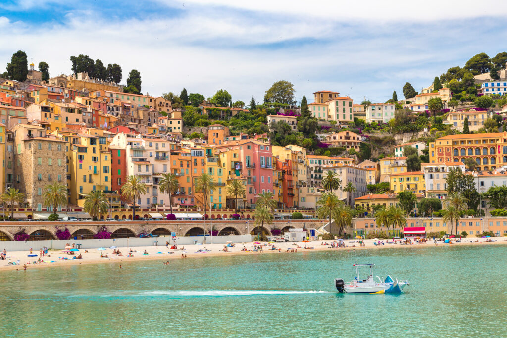 view of french riviera travel destination menton with water in the foreground and colorful city in the background